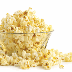 Large glass bowl of popcorn with popcorn overflowing on the side