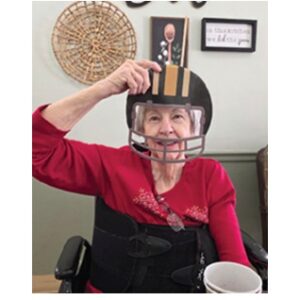 Kenwood Health and Rehab resident pictured with Superbowl photo props, helmet.